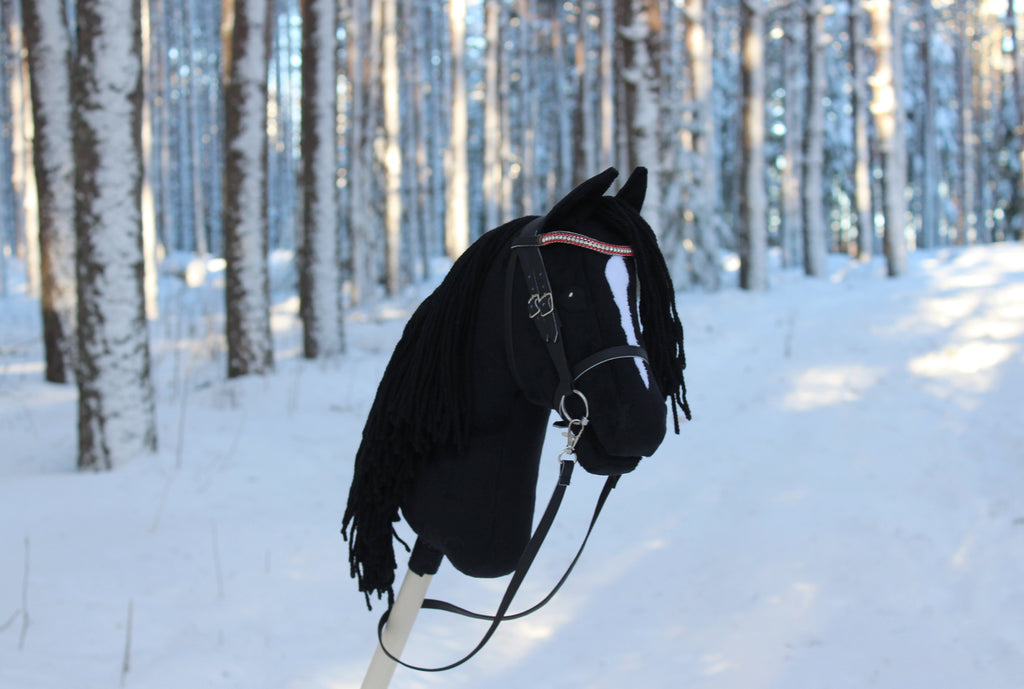 Musta keppihevonen suitsilla