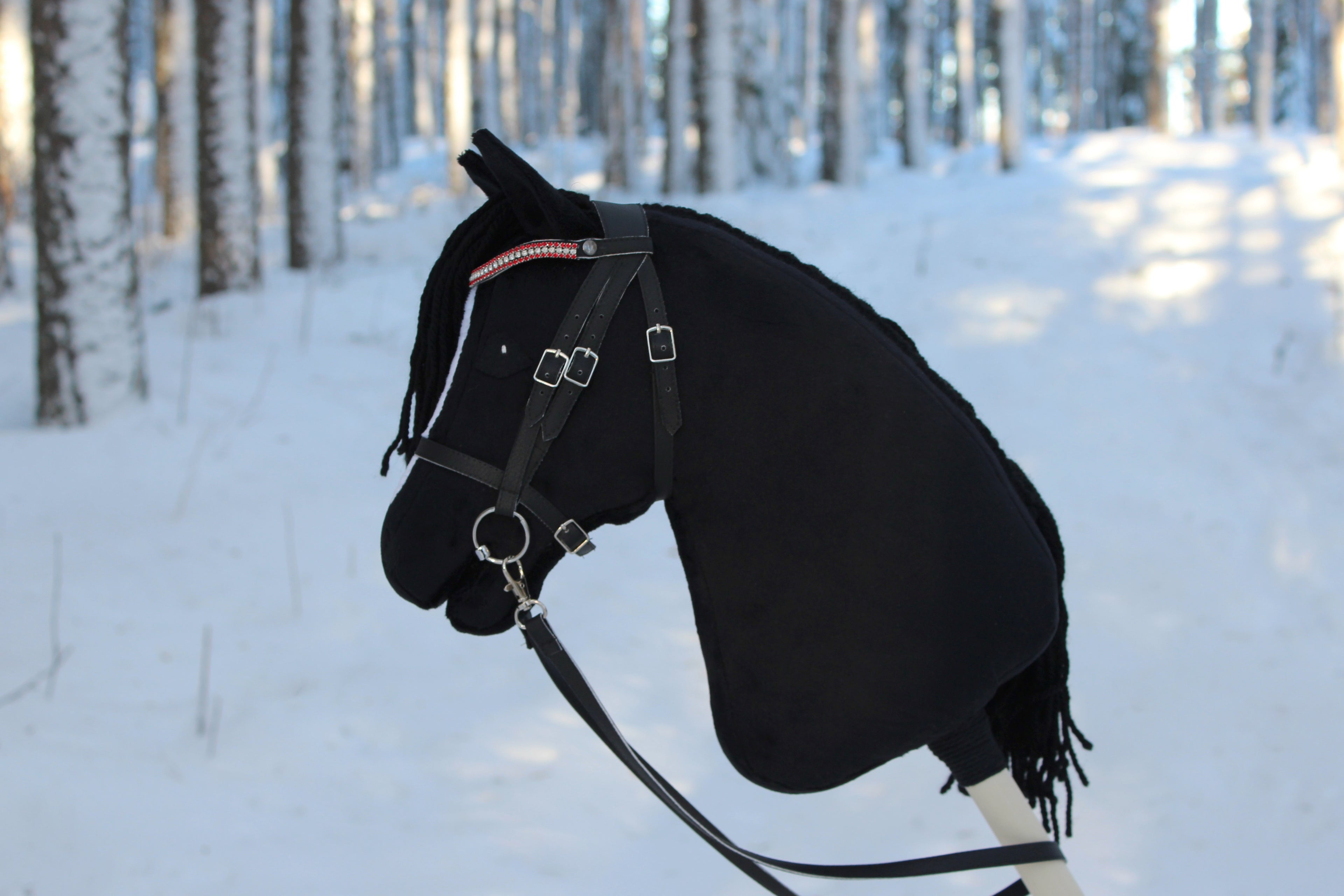 Musta keppihevonen suitsilla